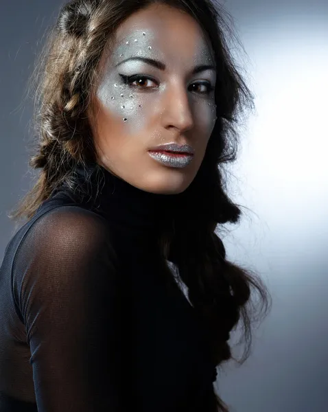 Портрет красивой молодой женщины с гламурным макияжем на темном фоне — стоковое фото