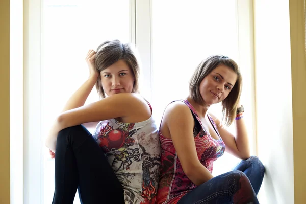 Две девушки на подоконнике — стоковое фото