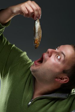 Hungry corpulent man staring at a fish