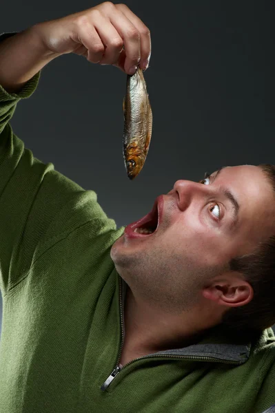 Hungriger korpulenter Mann, der auf einen Fisch starrt — Stockfoto