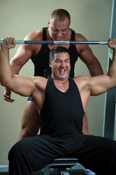 Två kroppsbyggare tränar i gymdvě kulturistů trénink v tělocvičně — Stockfoto