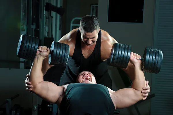 Två kroppsbyggare tränar i gymdvě kulturistů trénink v tělocvičně — Stock fotografie