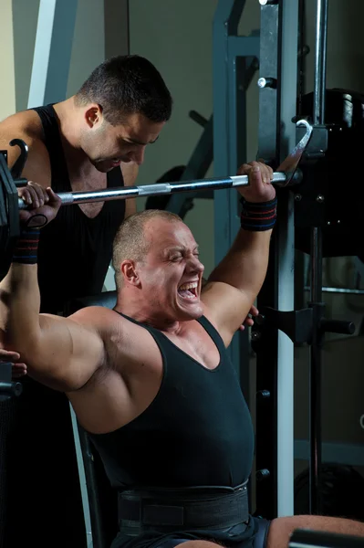 Två kroppsbyggare tränar i gymdvě kulturistů trénink v tělocvičně — Stockfoto