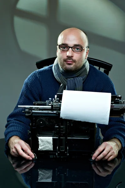 Altmodischer Glatzkopf mit Brille schreibt Buch auf einer alten Schreibmaschine — Stockfoto