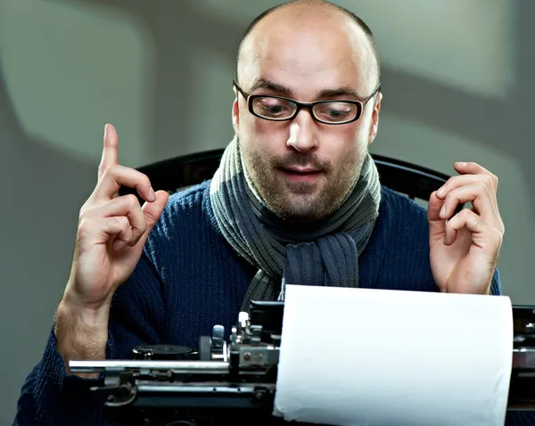Escritor careca à moda antiga em óculos escrevendo livro em uma máquina de escrever vintage — Fotografia de Stock
