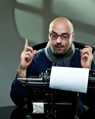 Old fashioned bald writer in glasses writing book on a vintage typewriter clipart