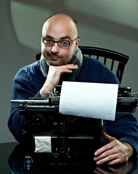 Vecchio scrittore calvo in occhiali scrittura libro su una macchina da scrivere vintage — Foto Stock