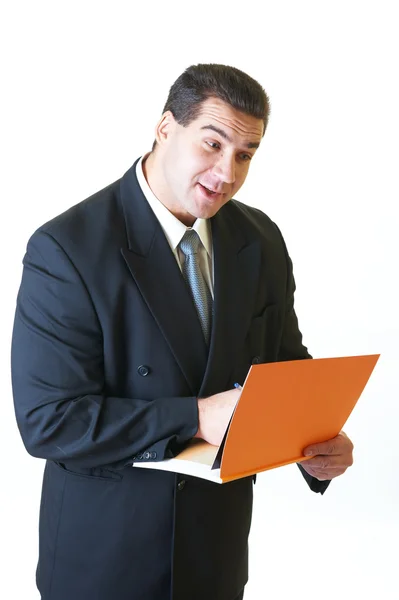 Aantrekkelijke man in zwart pak met oranje boek en pen geïsoleerde o — Stockfoto