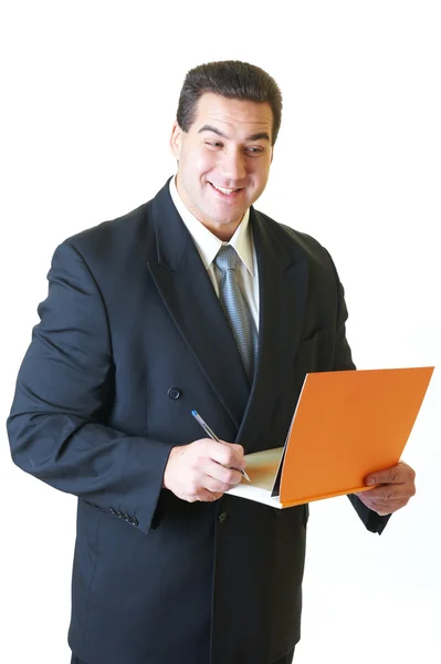 Aantrekkelijke man in zwart pak met oranje boek en pen geïsoleerde o — Stockfoto