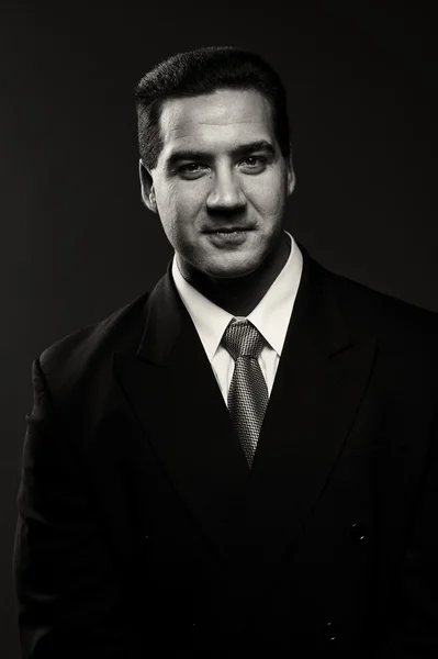 Mörka porträtt av stilig snygg ung man i svart kostym — Stockfoto