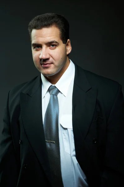 Dunkles Porträt eines gut aussehenden jungen Mannes im schwarzen Anzug — Stockfoto