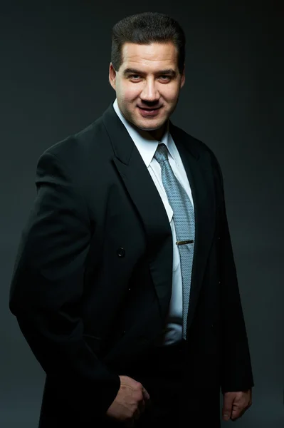 Dunkles Porträt eines gut aussehenden jungen Mannes im schwarzen Anzug — Stockfoto