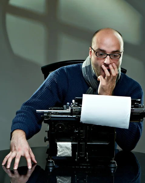 一个秃头的作家坐在一台打字机的肖像 — 图库照片