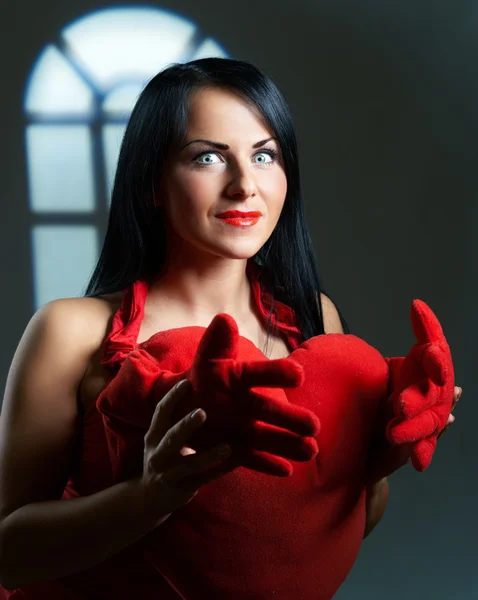Artistic portrait of beautiful young brunette with heart in hand — Stock Photo, Image