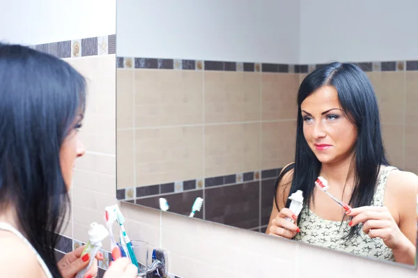 Mulheres perto de espelho escovar os dentes — Fotografia de Stock