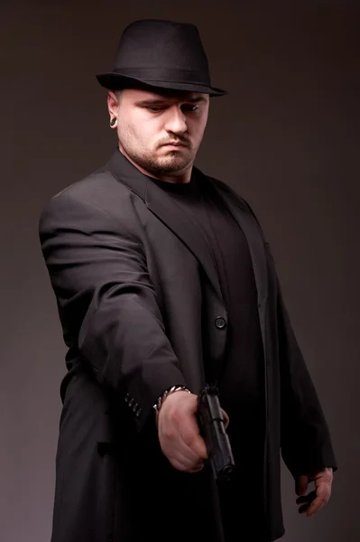 Uomo in suite nera con pistola . — Foto Stock
