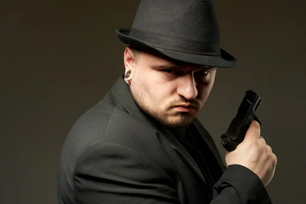 Man in black suite with gun. — Stock Photo, Image