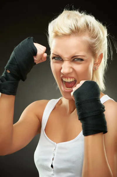 Jeune boxeuse blonde agressive avec des bandages sur les mains — Photo