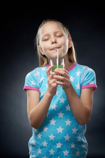 Little girl drinking juice, studio shot — Stock Photo, Image
