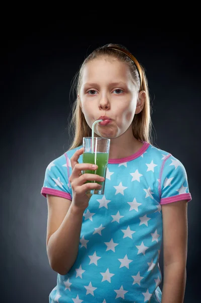 Little girl drinking juice, studio shot — Stock Photo, Image