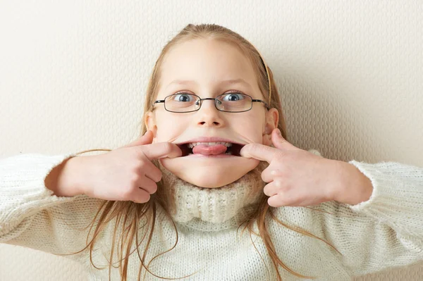 Divertente ritratto di una bambina con la lingua fuori — Foto Stock