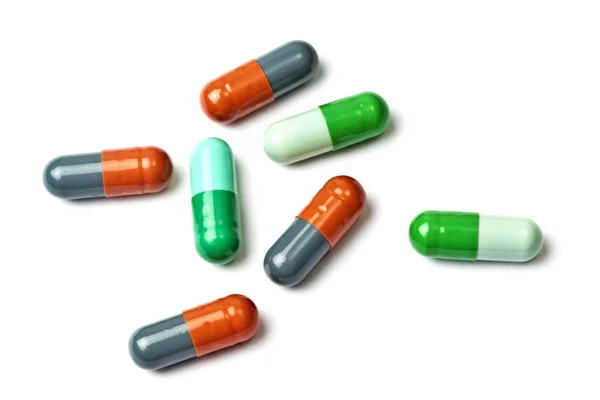 Een paar kleurrijke capsules geïsoleerd op wit — Stockfoto
