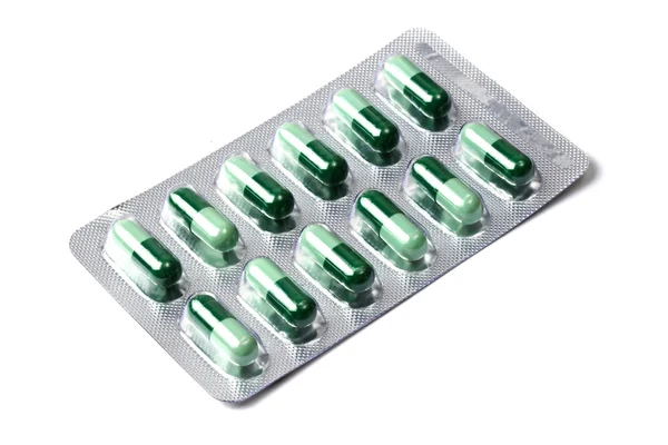 Paquet de capsules vertes isolées sur blanc — Photo