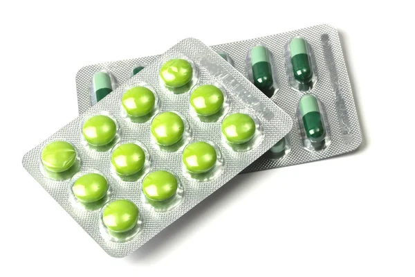 緑の錠剤やカプセルの白い背景で隔離 — ストック写真