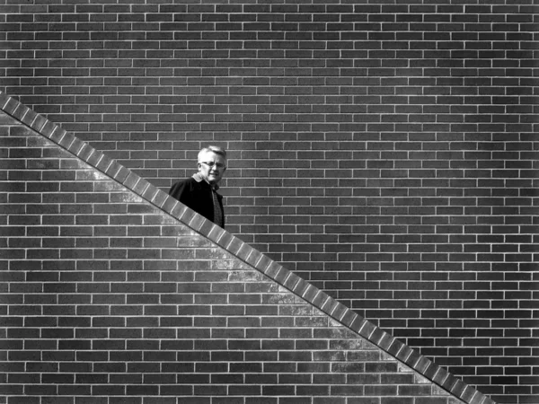 Чоловік Йде Сходами Цегляною Стіною Фоні — стокове фото