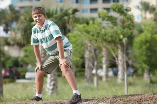 Мальчик с руками на коленях — стоковое фото