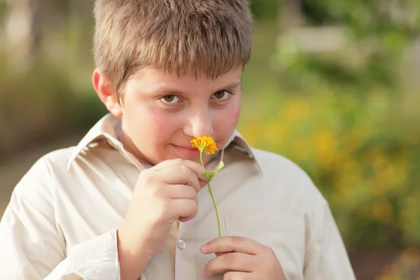 Niño pequeño oliendo una flor — Foto de Stock