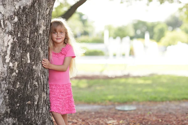Dívka schovává za stromem — Stock fotografie