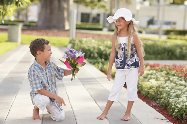 Oğlan kıza çiçek vererek — Stok fotoğraf