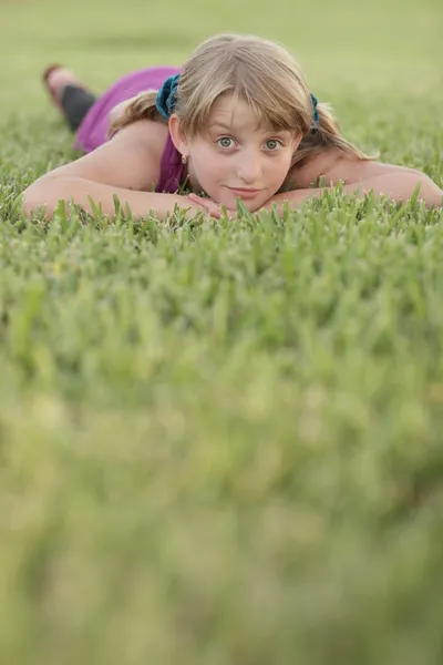 Meisje op het gras te leggen — Stockfoto