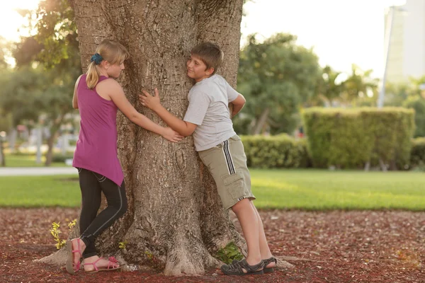 Crianças abraçando a árvore — Fotografia de Stock