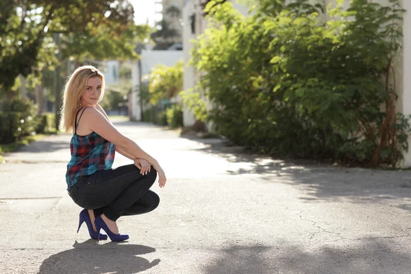 Woman squatting in fashionable clothing — Stock Photo, Image