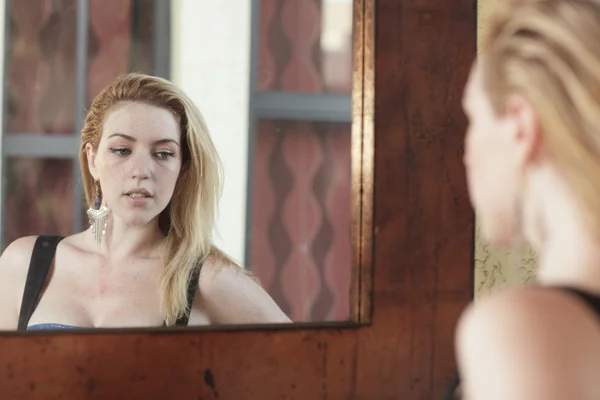 Frau blickt in den Spiegel — Stockfoto