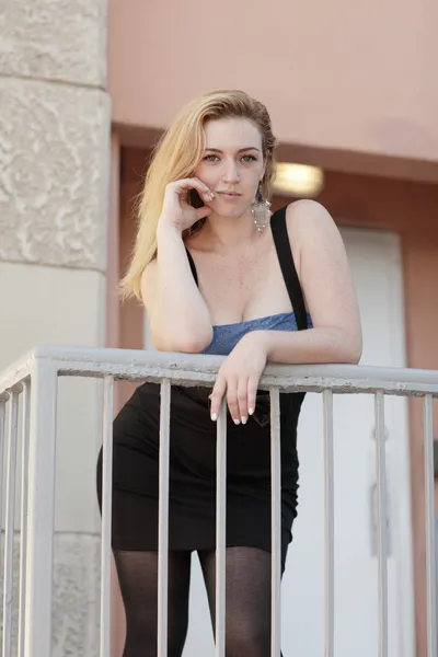 Attraktive junge Frau lehnt an einem Geländer — Stockfoto