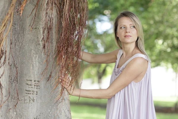 Kvinna poserar av ett träd — Stockfoto