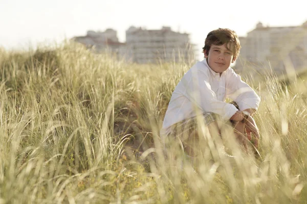 Ragazzo seduto tra le dune — Foto Stock