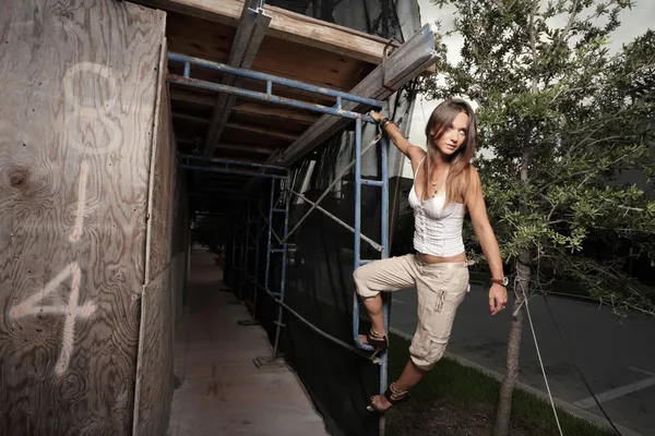 Kvinna hängande från byggnadsställningar — Stockfoto