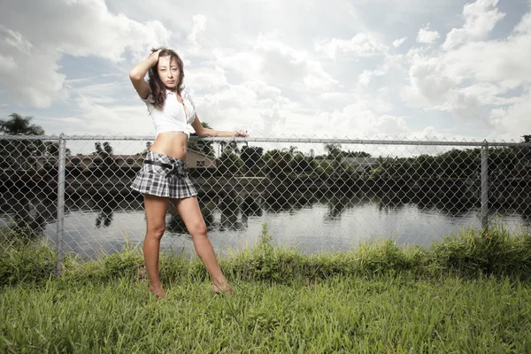 Kvinna poserar av staketet — Stockfoto
