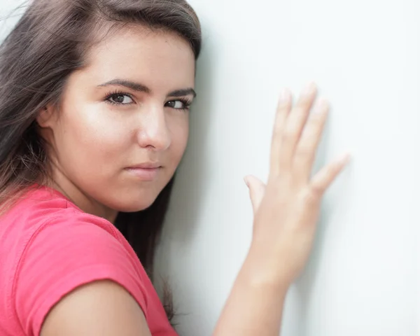 Vrouw met haar hand op de muur — Stockfoto