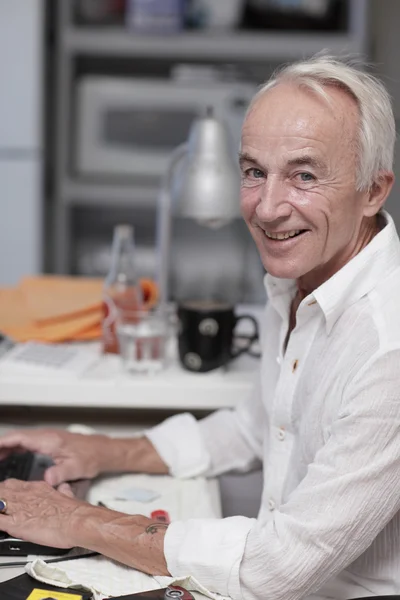 Senior mannetje op zijn computer — Stockfoto