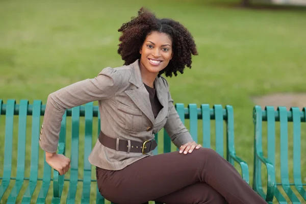 Kvinnan sitter på en bänk — Stockfoto