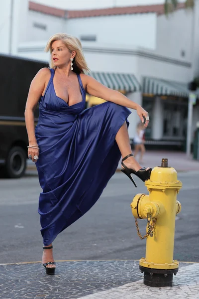 她的腿靠在消防栓上摆姿势 — 图库照片