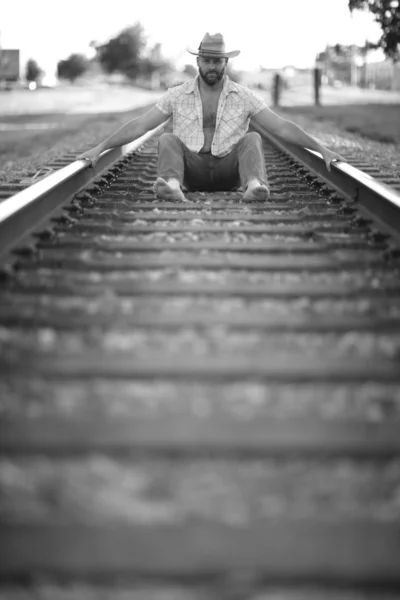 Hombre sentado entre las vías — Foto de Stock