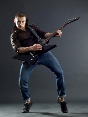 Passionate guitar player isolated against dark background clipart