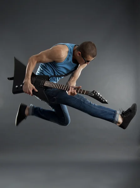 Rock star jumping with guitar — Stock Photo, Image