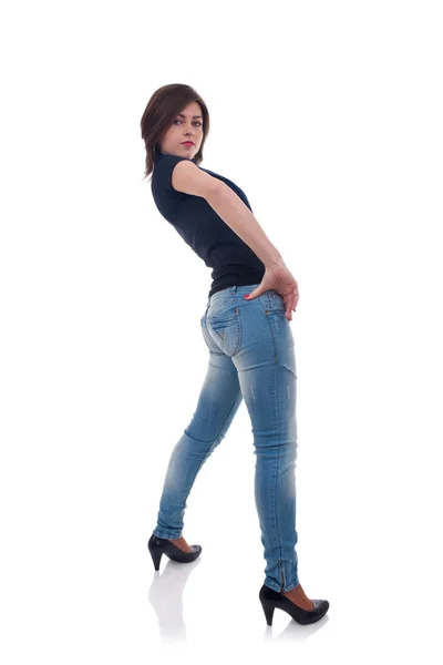 后面一个性感的女孩在摆了工作室的牛仔裤 — 图库照片